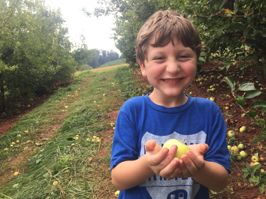 Brendon holding apples he picked while fall camping