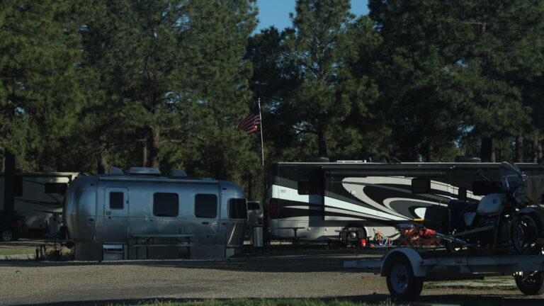 RVs parked at a campsite next to an American flag - photo by Fiorella Yriberry