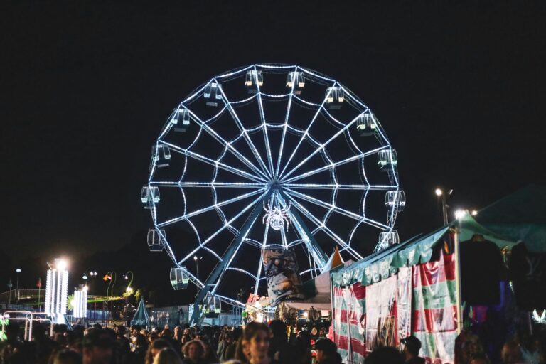 A large ferris wheel looms over a crowd at a fair in Raleigh, NC