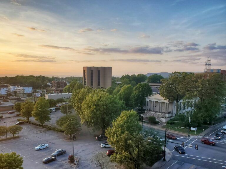 Greenville at sunset, showing roads, buildings, and trees with mountains in the distance.