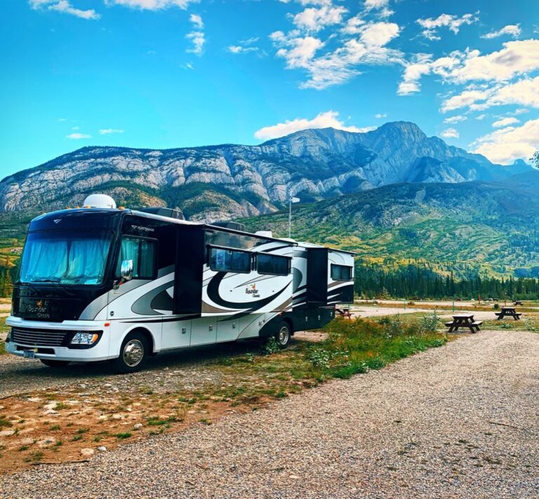 A class A RV sitting in front of mountains