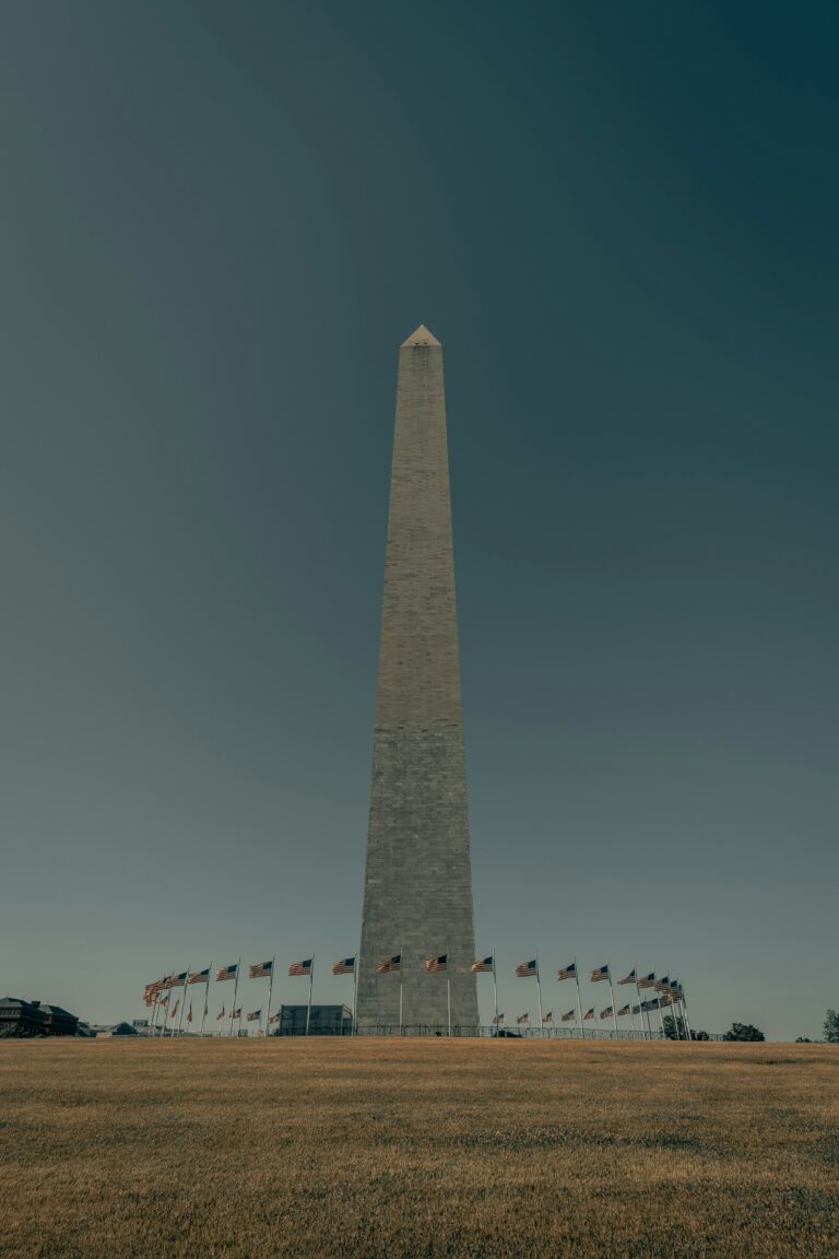 Washington Monument, a tall obelisk structure surrounded by American flags