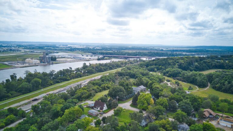 The green trees and hills of Omaha as seen from above on a cloudy afternoon.