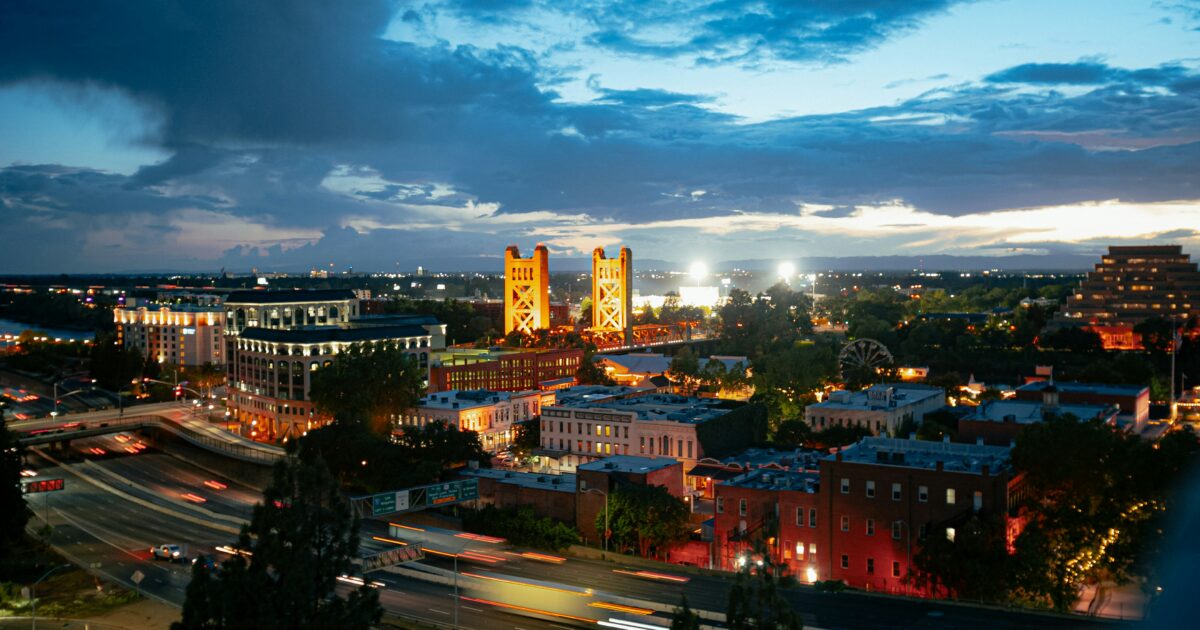 Downtown Sacramento lit up under an evening sky