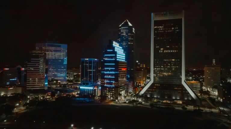 Lit up Jacksonville skyscrapers at night, with one saying 