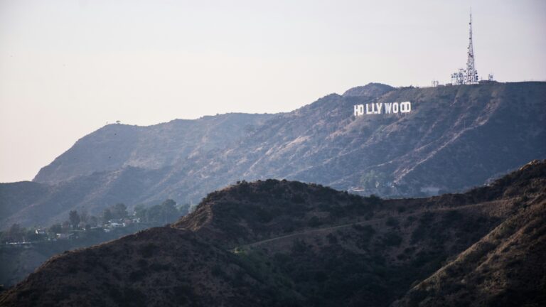 Hollywood sign on hillside, visible across rugged terrain.