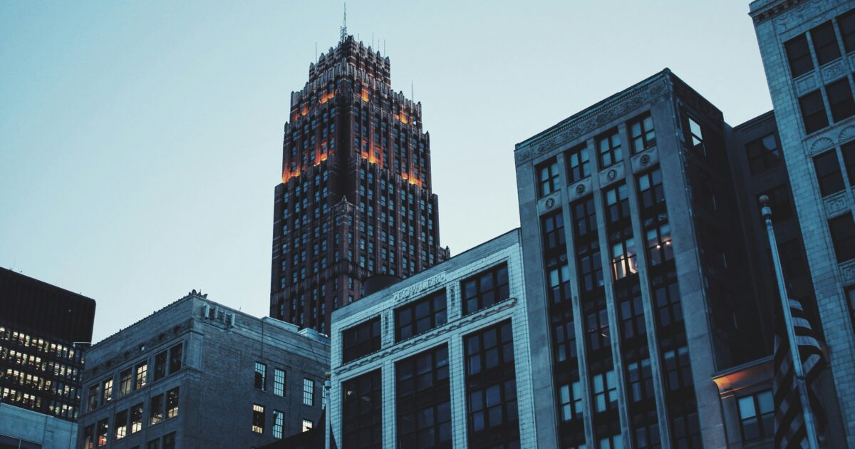 A US flag flies in front of city buildings in downtown Detroit