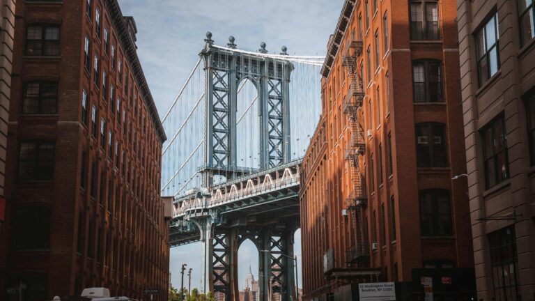 Red brick buildings in Brooklyn with the Manhattan Bridge visible between them
