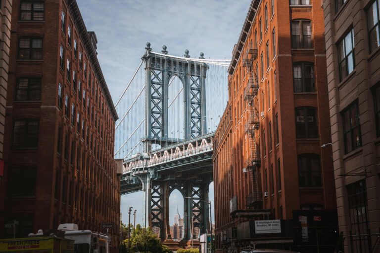 Red brick buildings in Brooklyn with the Manhattan Bridge visible between them