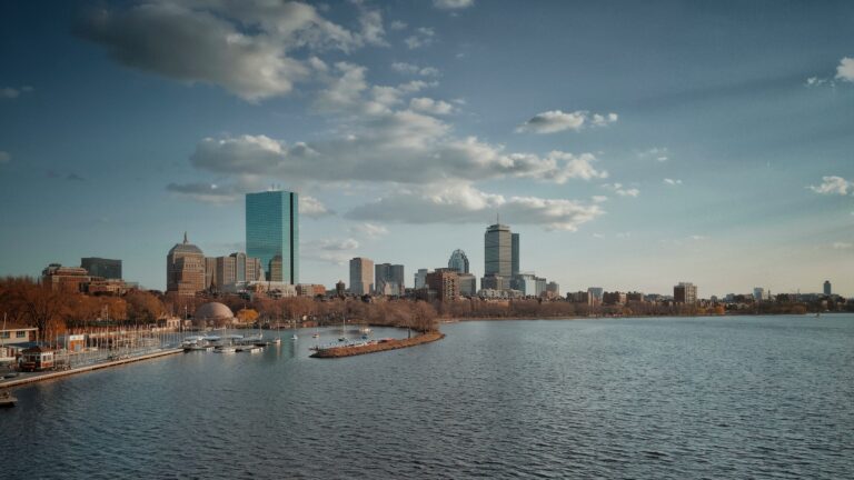 City skyline across a body of water under a blue and white cloudy sky during daytime