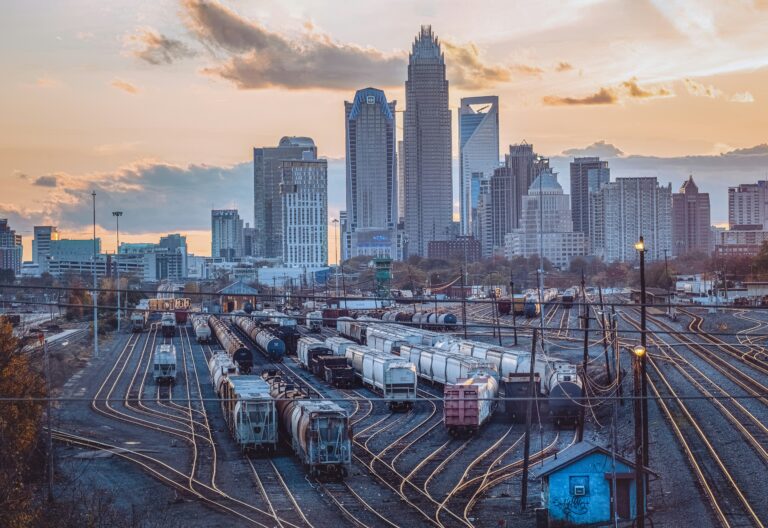 Scenic view of urban trainyard with Charlotte's skyline of tall buildings in the background.