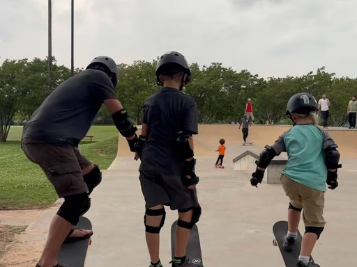 family practicing skating hobbies in local park 