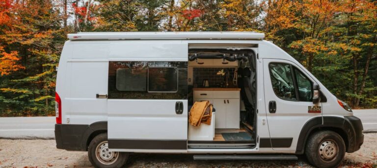 A Class B campervan with fall foliage behind it