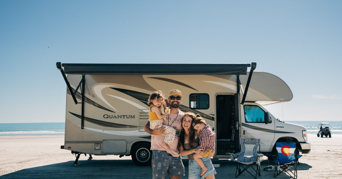 family standing in front of a class c rv