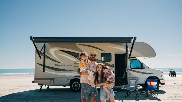 family standing in front of a class c rv
