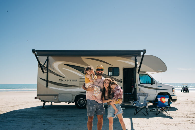 family standing in front of a class c rv