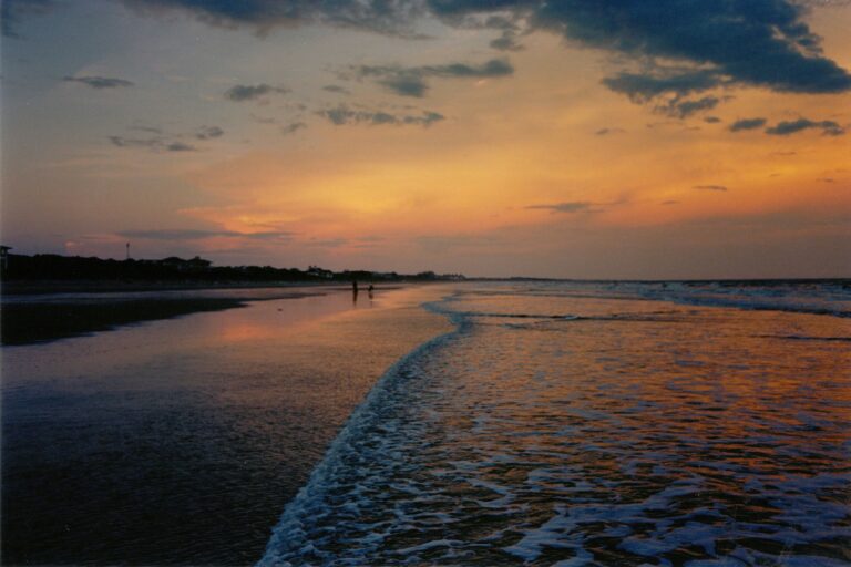 The Kiawah Island shoreline, featuring an amber sunset as the tide comes in.