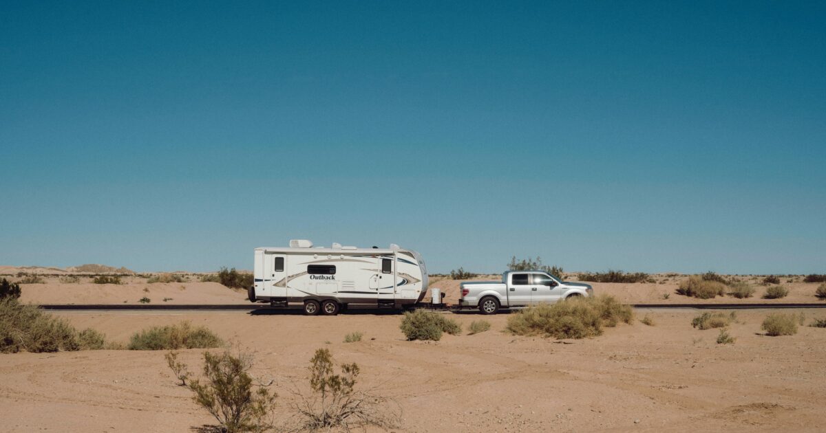 travel trailer RV getting towed by a truck on the road