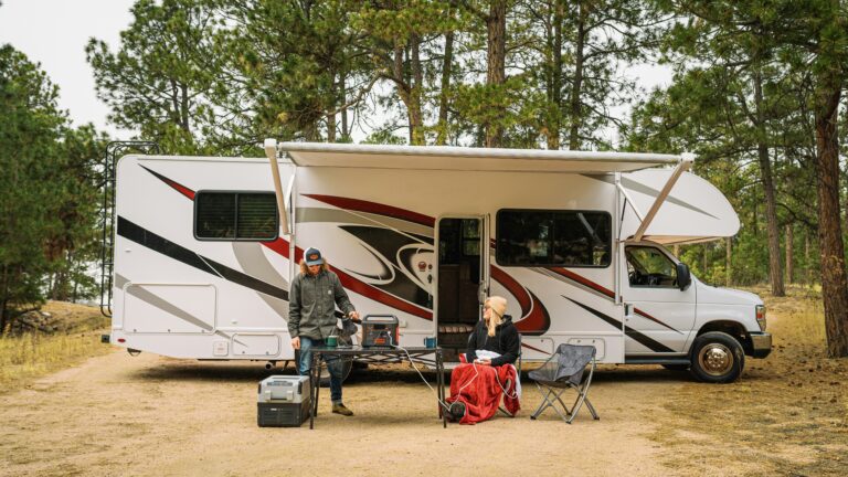 Two people outside of motorhome enjoying their RV rental