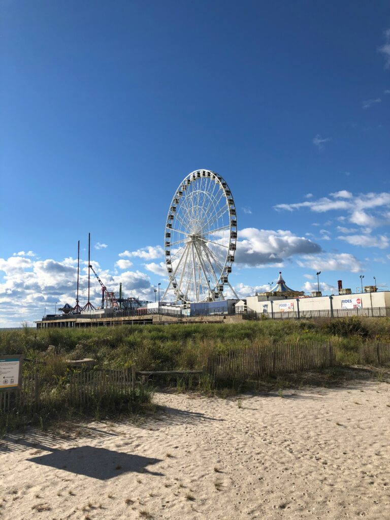 View of the boardwalk and Ferris wheel in Atlantic City from the public beach