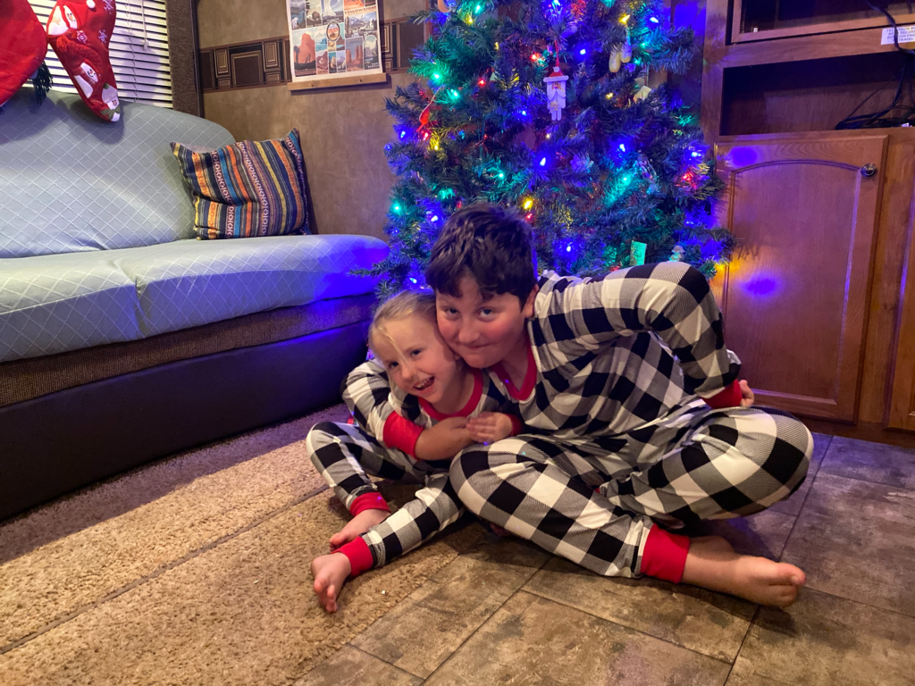 Kids sitting in front of Christmas tree in RV