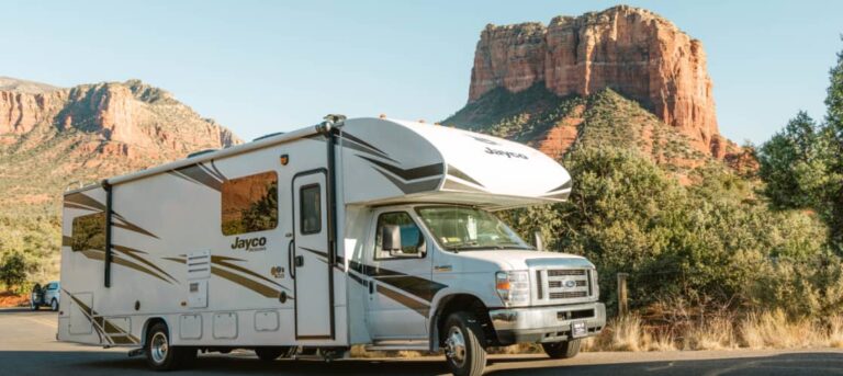 A class C RV parked in a scenic area on an RV road trip