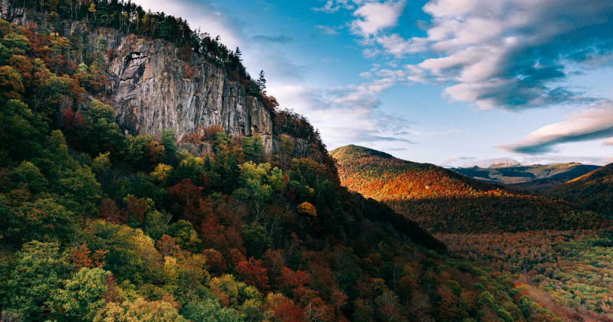Stunning fall foliage lines the granite peaks of White Mountain National Forest in New Hampshire, a destination dupe for Acadia National Park