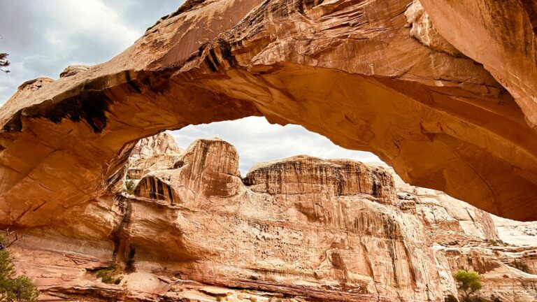 A red sandstone arches towers gracefully over the landscape at Capitol Reef National Park, a destination dupe for Zion National Park