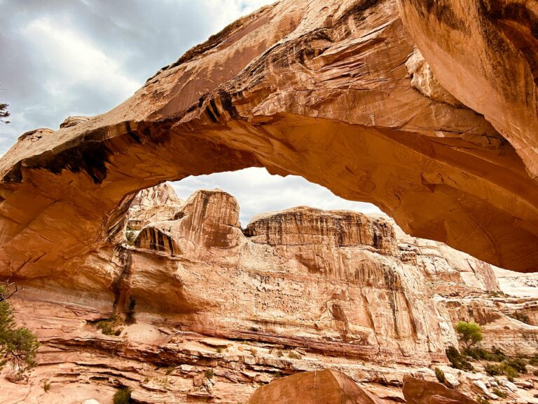 A red sandstone arches towers gracefully over the landscape at Capitol Reef National Park, a destination dupe for Zion National Park