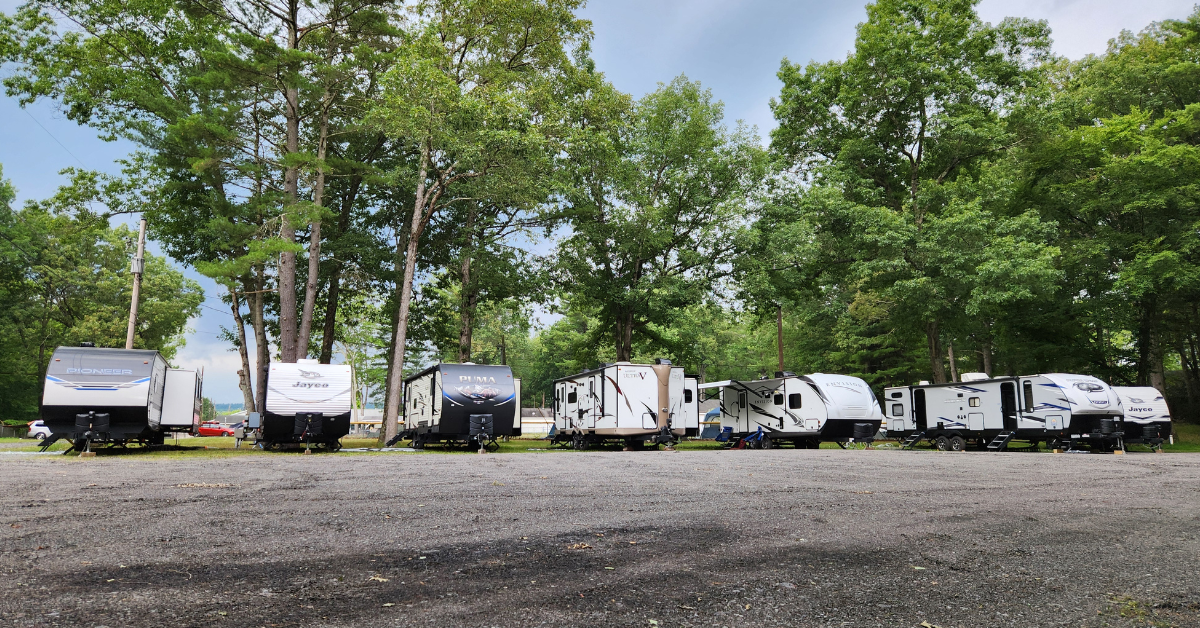 Row of RVs parked at a campground under trees