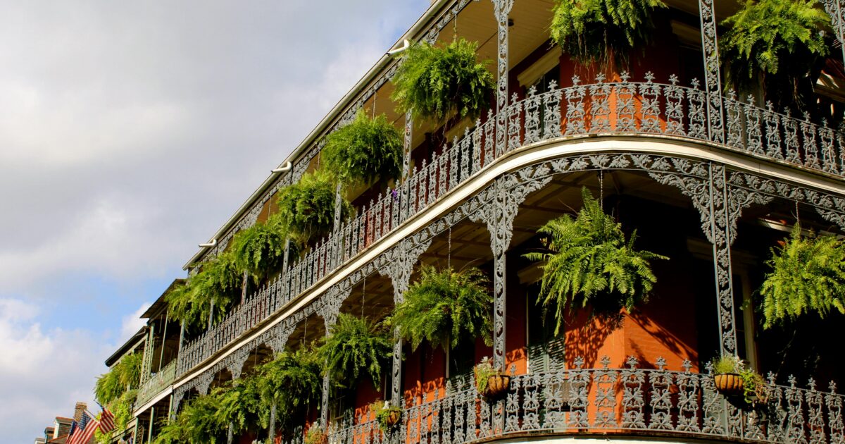 French colonial architecture on a building overlooking New Orleans' French Quarter, an international destination dupe in the southeastern U.S.