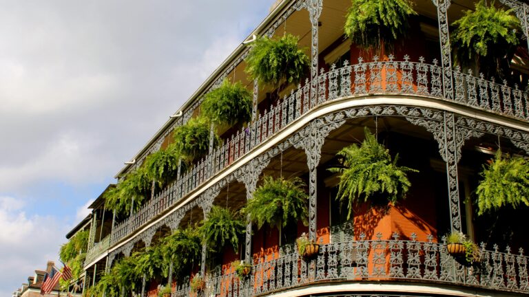 French colonial architecture on a building overlooking New Orleans' French Quarter, an international destination dupe in the southeastern U.S.
