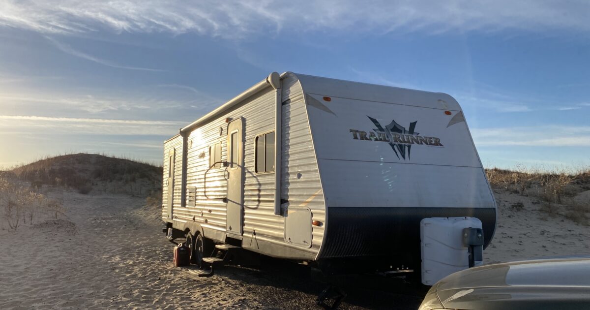 Our travel trailer parked by sand dunes in Texas