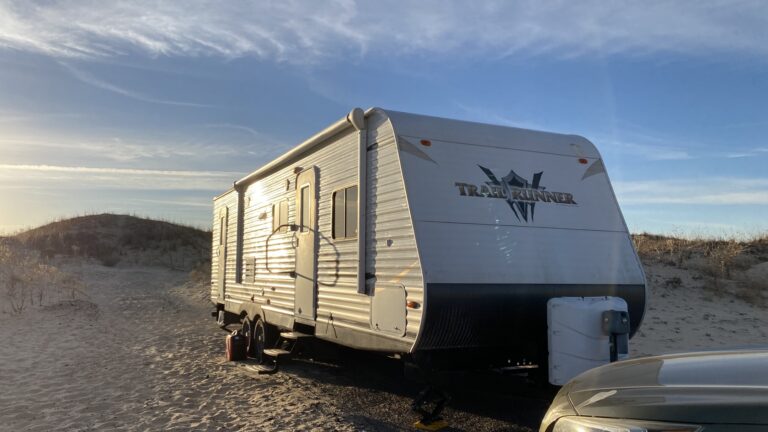 Our travel trailer parked by sand dunes in Texas