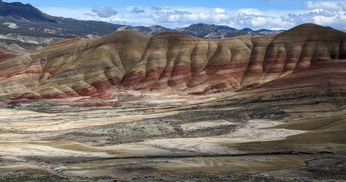 The Painted Hills of Oregon, with their gold and red stripes, under a blue sky