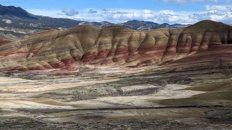 The Painted Hills of Oregon, with their gold and red stripes, under a blue sky