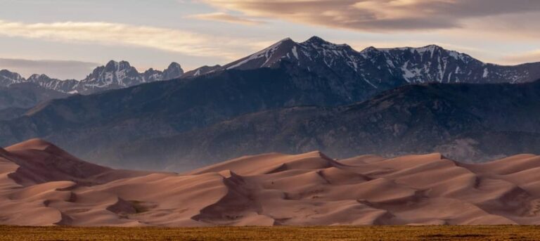 the sand dunes at Great Sand Dunes National Park are framed by the Sangre de Cristo Mountains in the background. This is a great spot for camping in Colorado