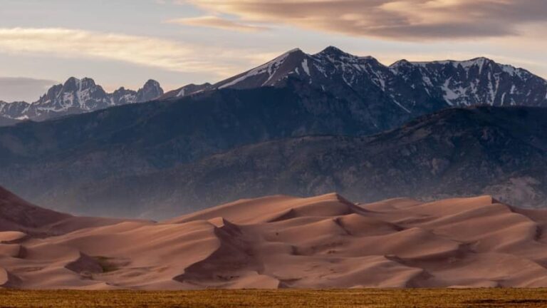 the sand dunes at Great Sand Dunes National Park are framed by the Sangre de Cristo Mountains in the background. This is a great spot for camping in Colorado