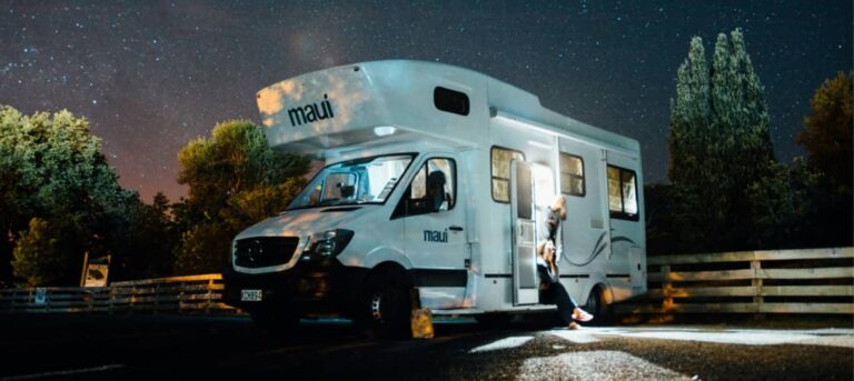 an RV set up at a campsite with stars behind it. RVing is a great way to see the Perseid meteor shower 2025