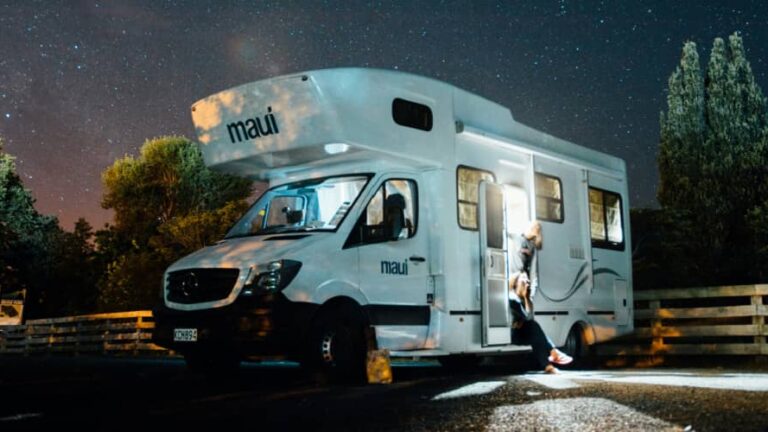 an RV set up at a campsite with stars behind it. RVing is a great way to see the Perseid meteor shower 2025