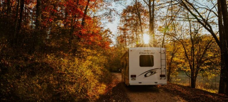 an RV driving through fall foliage