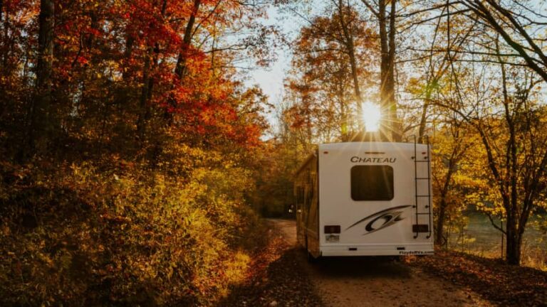 an RV driving through fall foliage