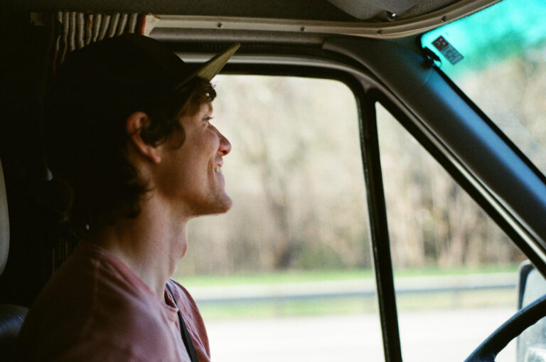 Man with a hat sitting in the driver's seat of an RV