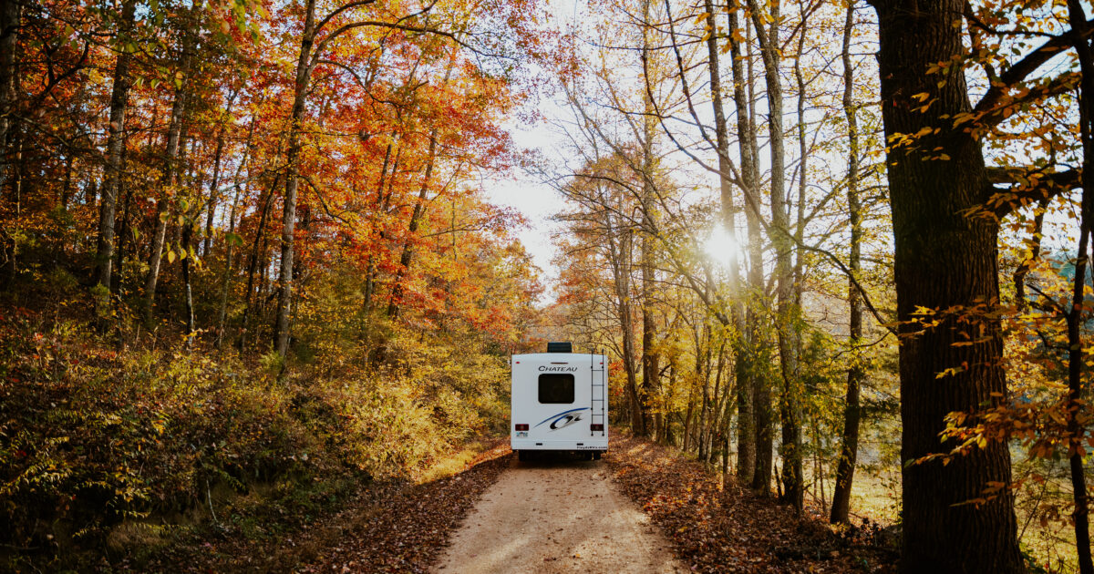 an RV driving through beautiful fall foliage