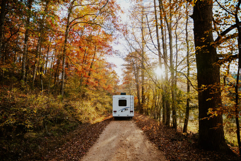 an RV driving through beautiful fall foliage