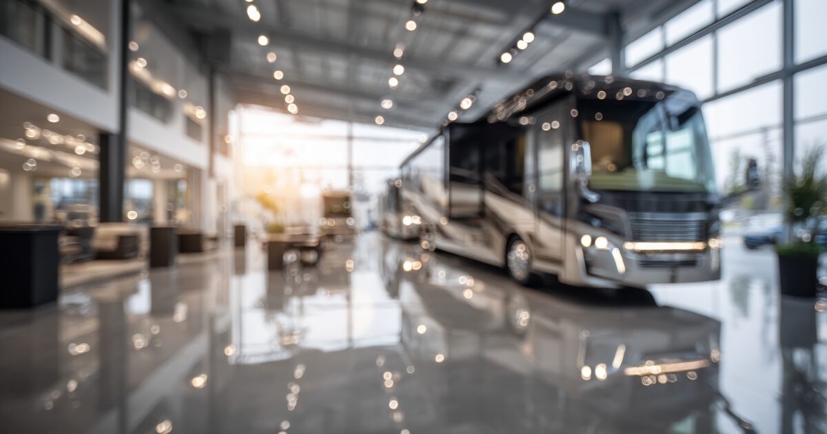 Shot capturing a luxury RV display centered in sharp focus against a softly blurred background of expansive dealership space reflecting sophistication and modern design.