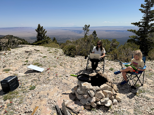 Bluetti Elite 200 V2 in use outside powering a starlink while family wokrs in their laptop outside.