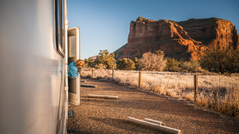 young boy peeking out of an rv and looking at a red rock formation