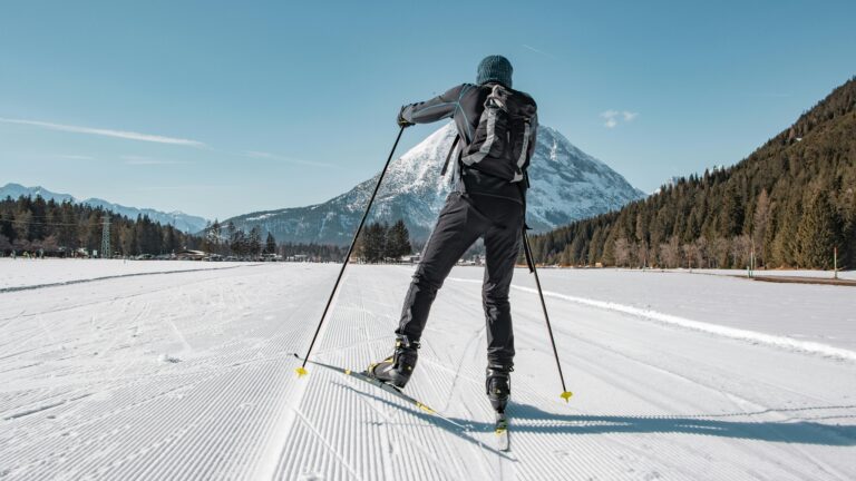 A cross-country skiier in front of a mountain peak. The national parks are a great place to try out Olympic winter sports