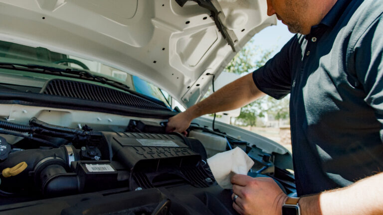 man looking under the hood of his RV
